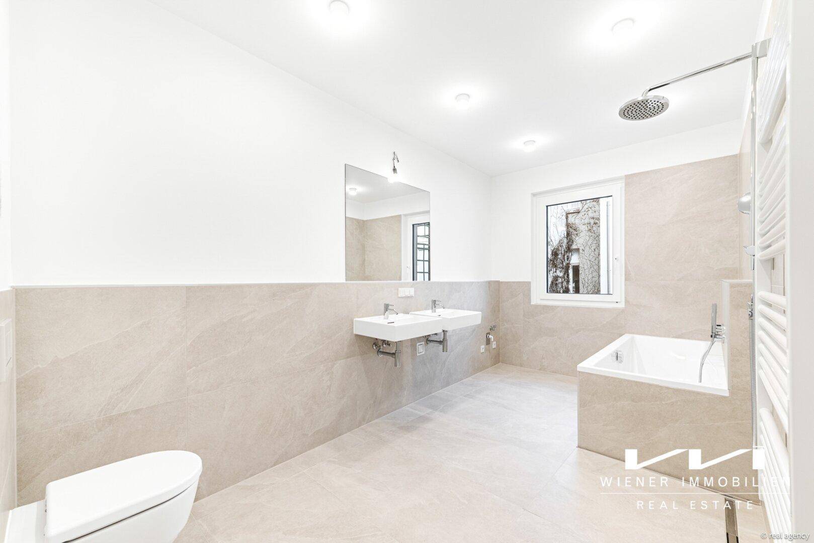 Modernes Badezimmer mit Doppelwaschbecken, Badewanne, Regendusche und Fenster.