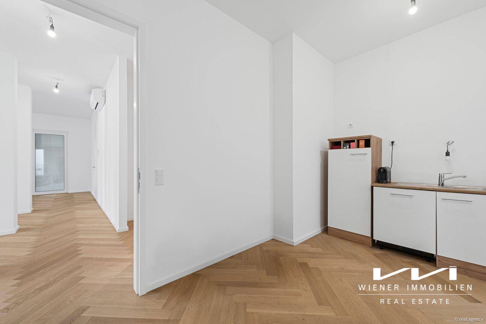 Kleine, funktionale Küchenzeile mit Spüle und Stauraum, ideal für eine kompakte Wohnung.