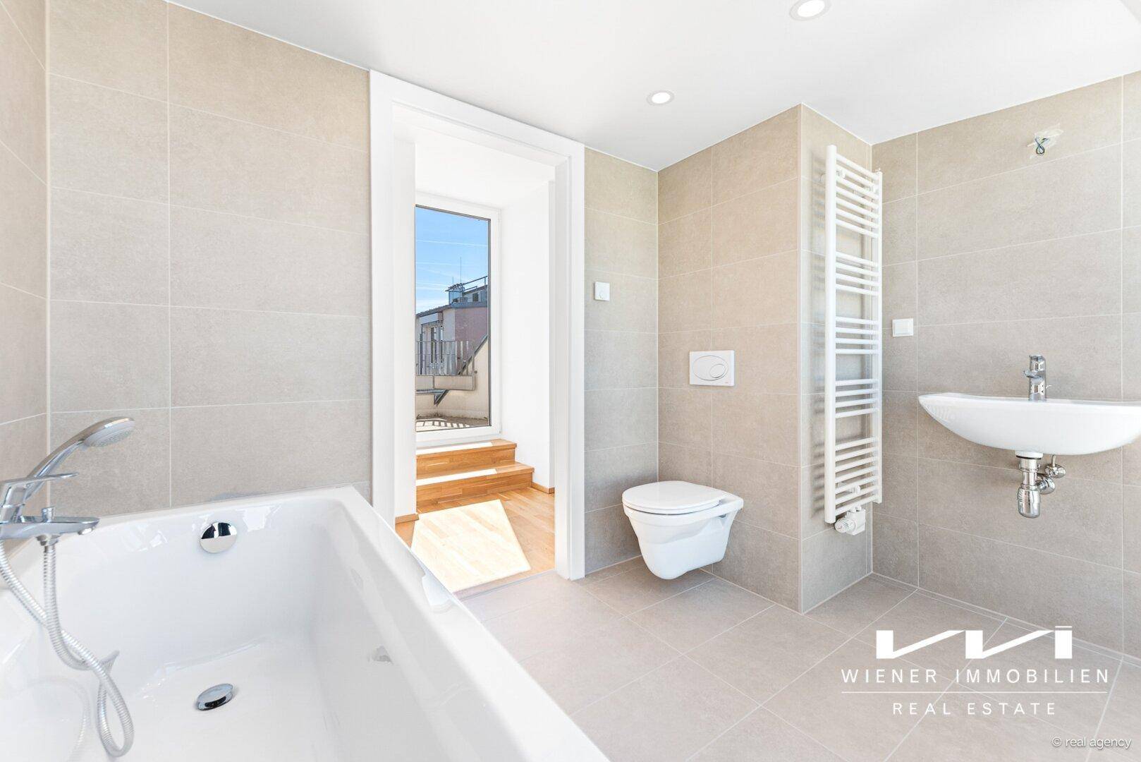 Helles Badezimmer mit Badewanne, wandhängendem WC, Waschbecken und beheiztem Handtuchhalter.
