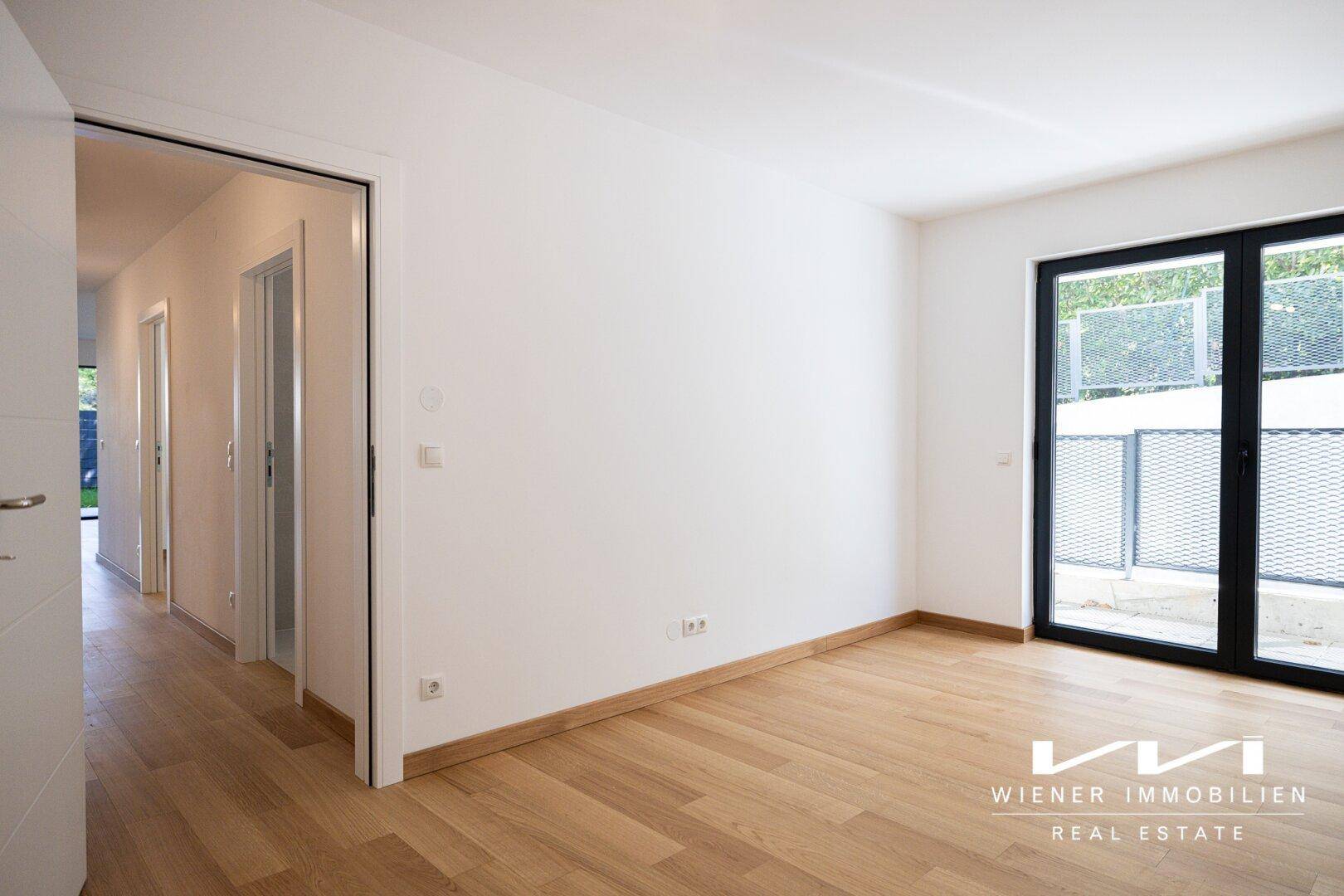 Geräumiges Zimmer mit hellem Parkettboden und direktem Zugang zum Flur.