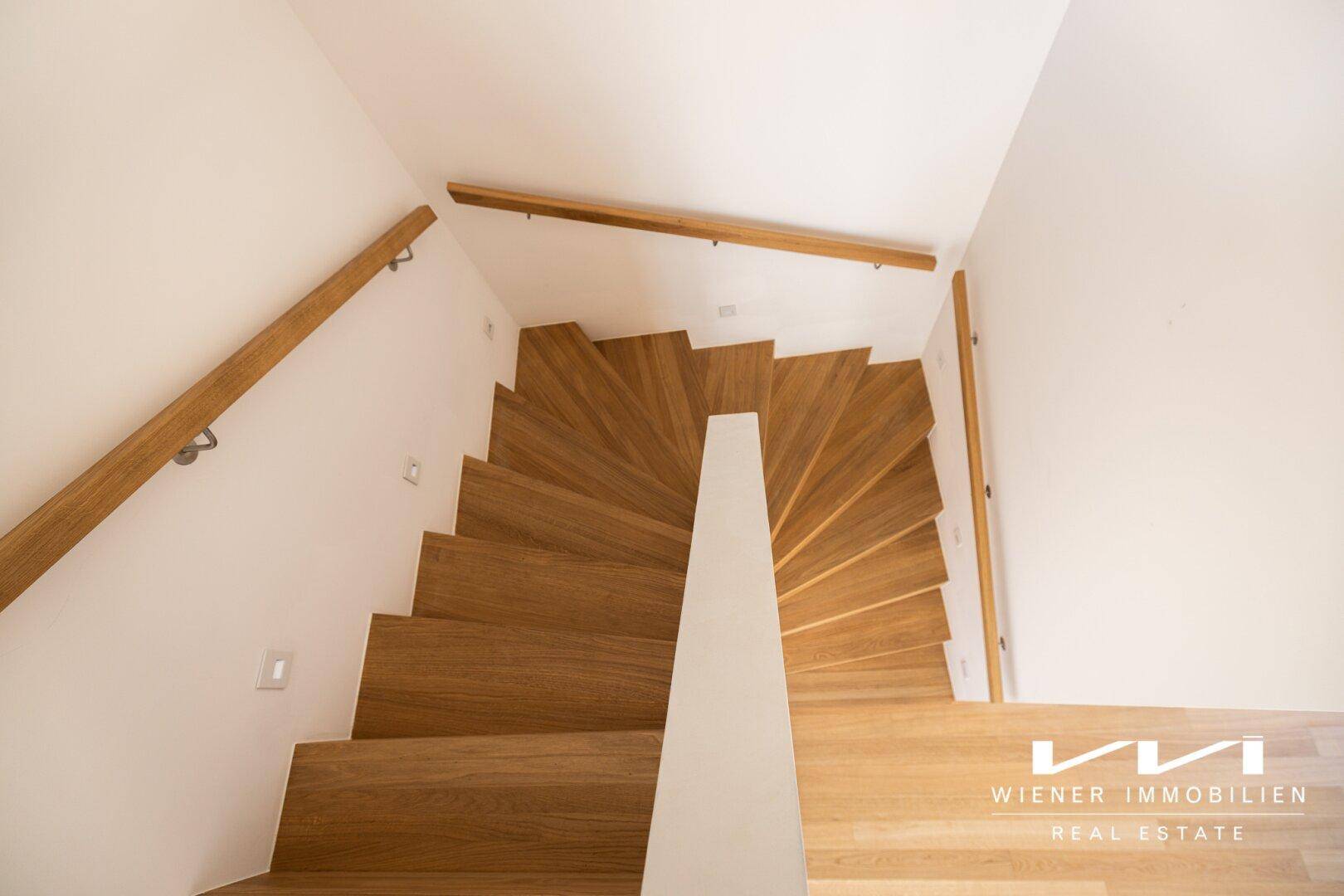 Elegante Holztreppe mit modernem Design, die die verschiedenen Ebenen des Hauses verbindet.