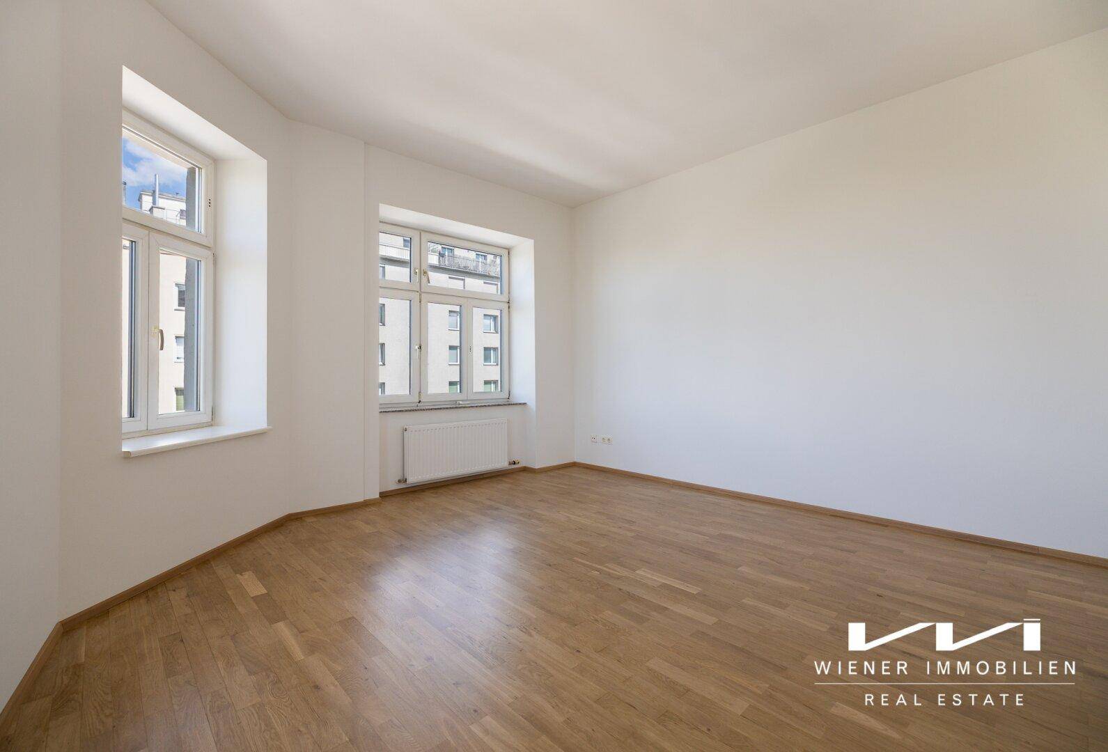 Helles Zimmer mit Parkettboden und zwei Fenstern, ideal als Schlaf- oder Arbeitszimmer.