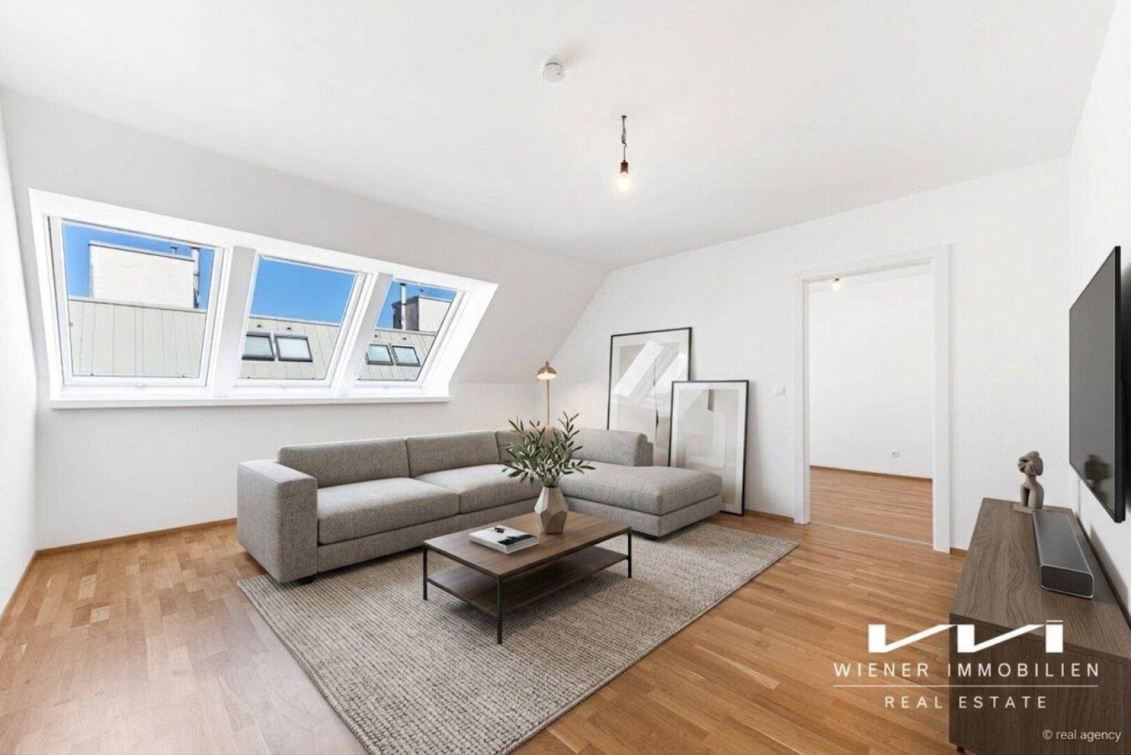 Lichtdurchflutetes Dachgeschoss-Wohnzimmer mit Schrägfenstern, Holzboden und zeitgemäßer Einrichtung.