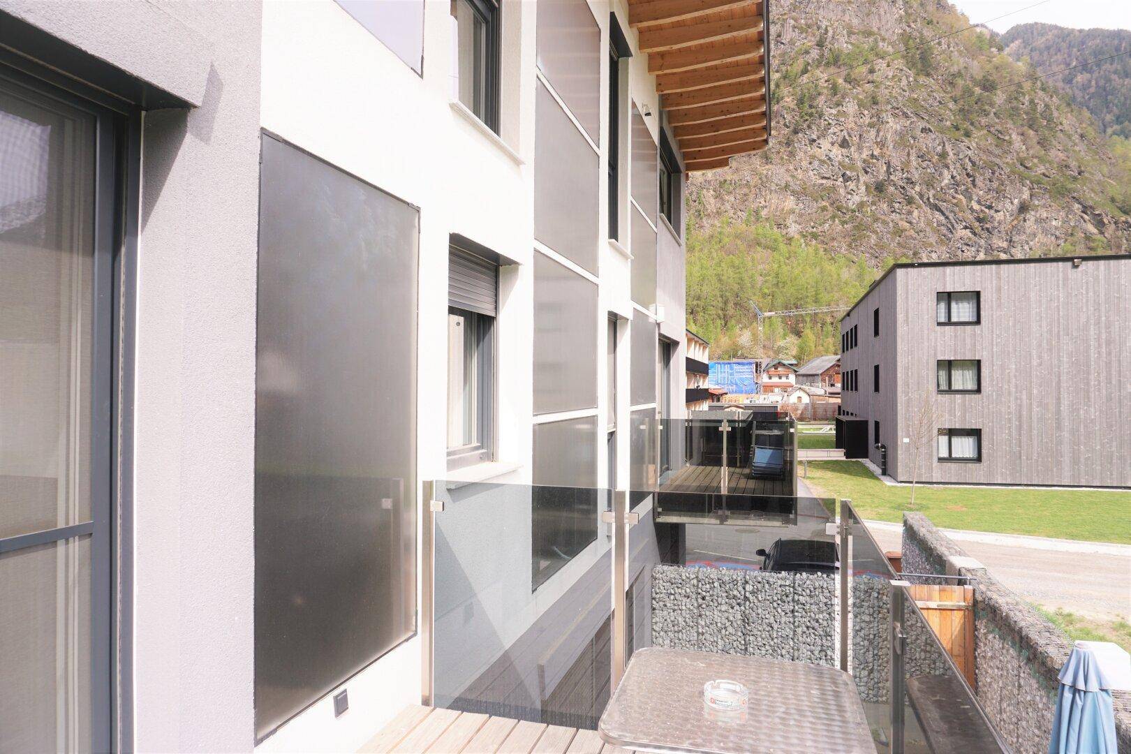 Balkon mit Glasgeländer und Sitzgelegenheiten, bietet einen angenehmen Ausblick auf die Umgebung.