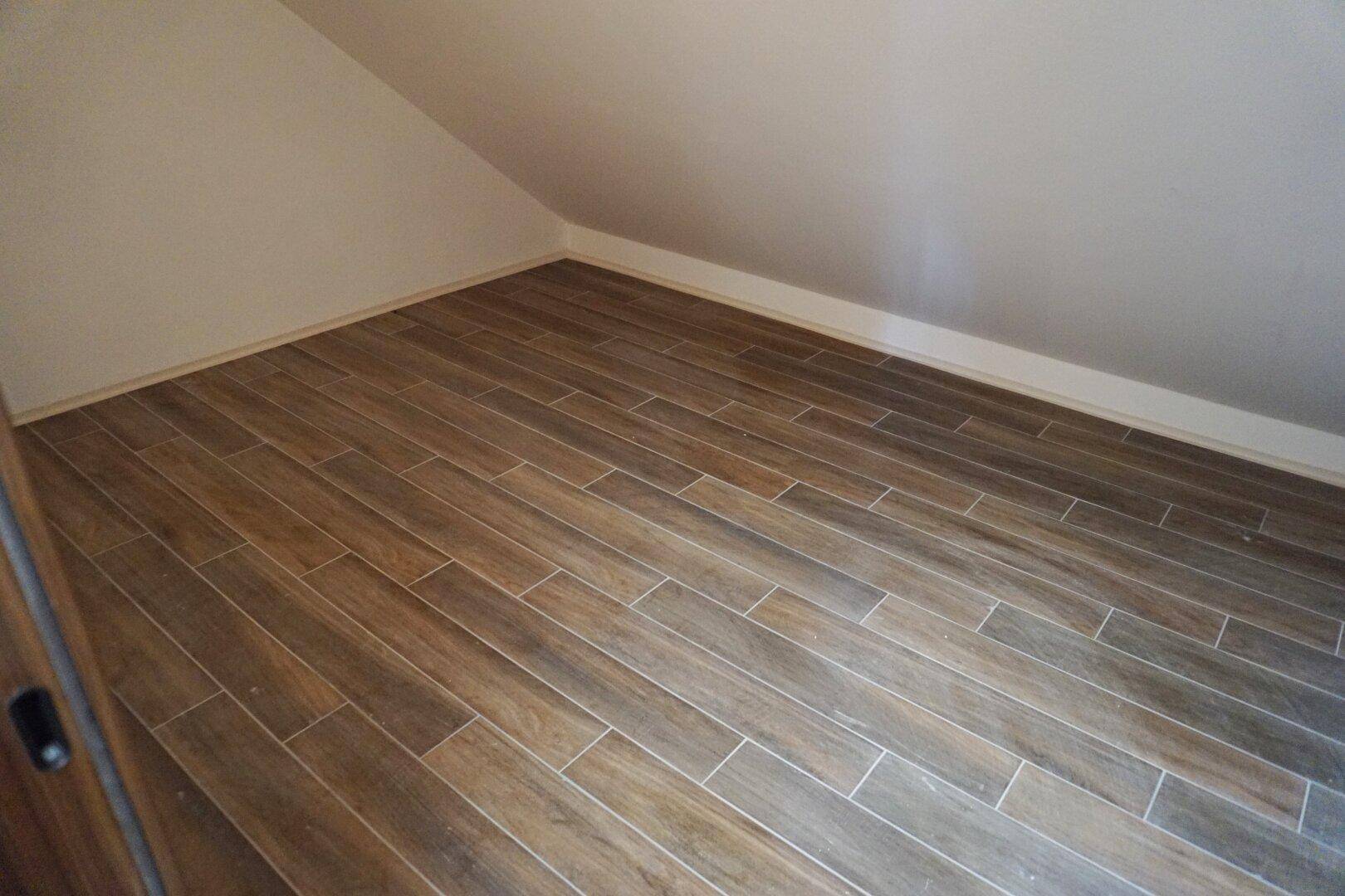 Leerer Raum im Dachgeschoss mit Holzboden und schräger Decke, ideal als Abstellraum.