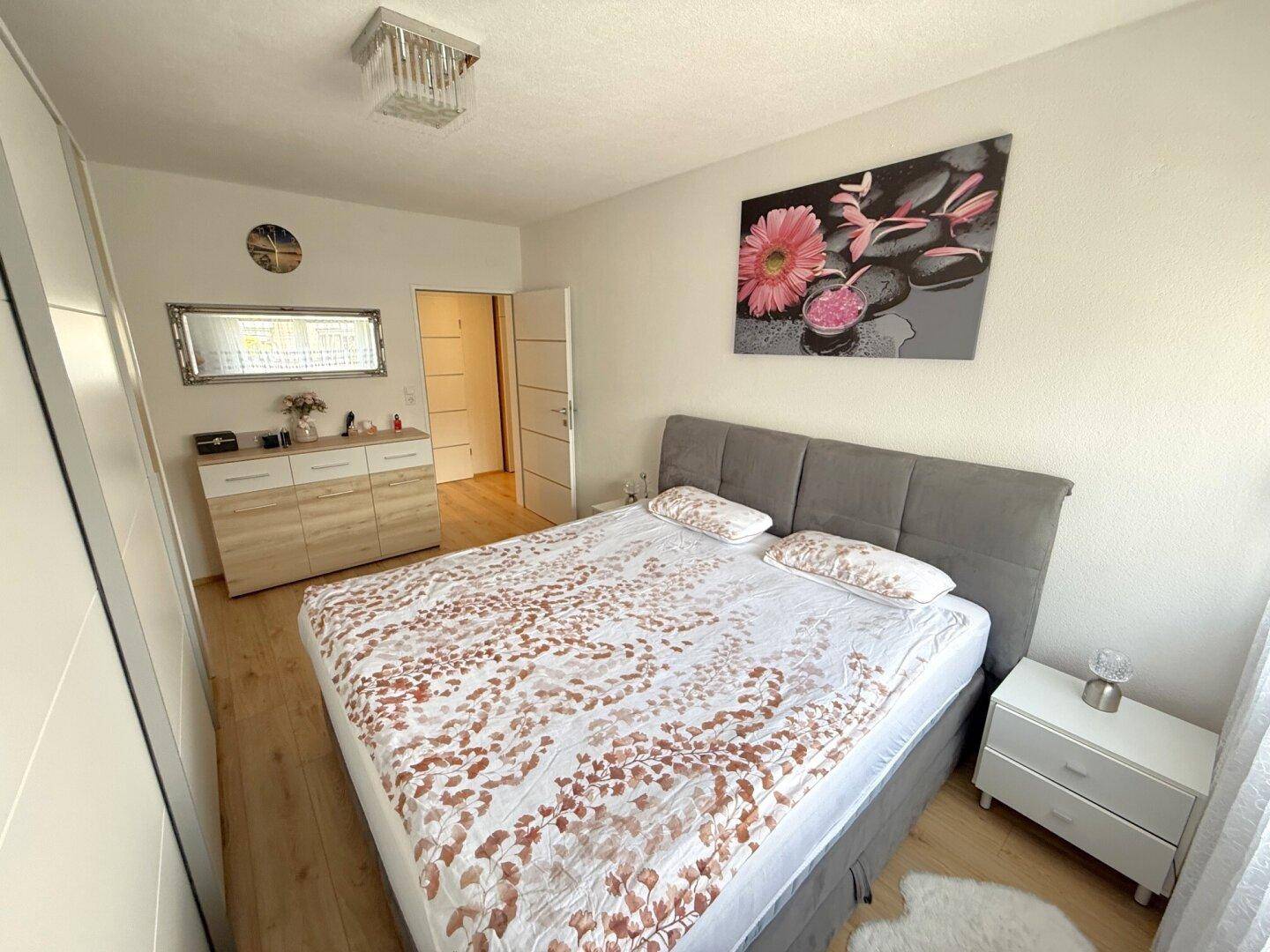 Gemütliches Schlafzimmer mit Doppelbett, Nachttischen und modernem Dekor.