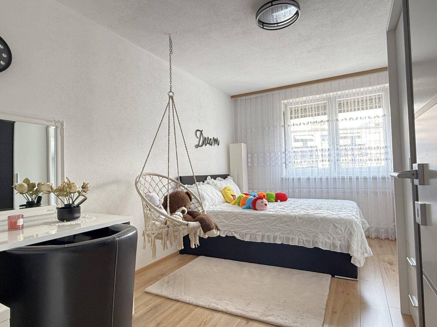 Kinderzimmer mit Schaukelstuhl, Einzelbett und verspielter Dekoration.