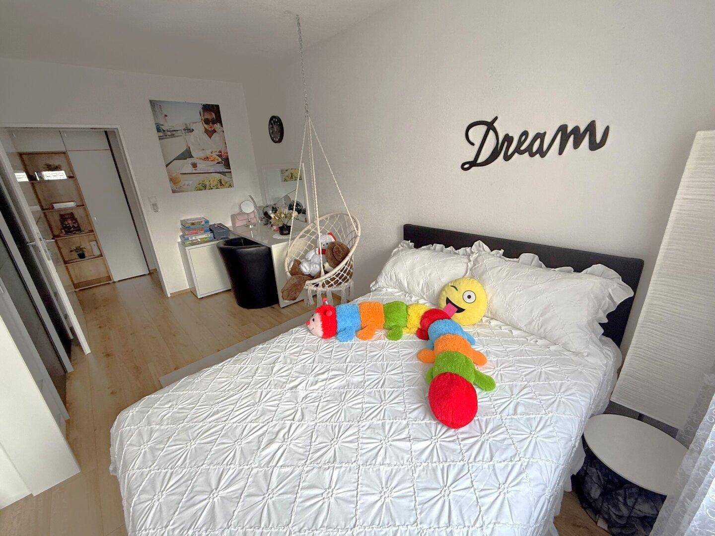 Helles Kinderzimmer mit Einzelbett, Schaukelstuhl und viel Platz zum Spielen.