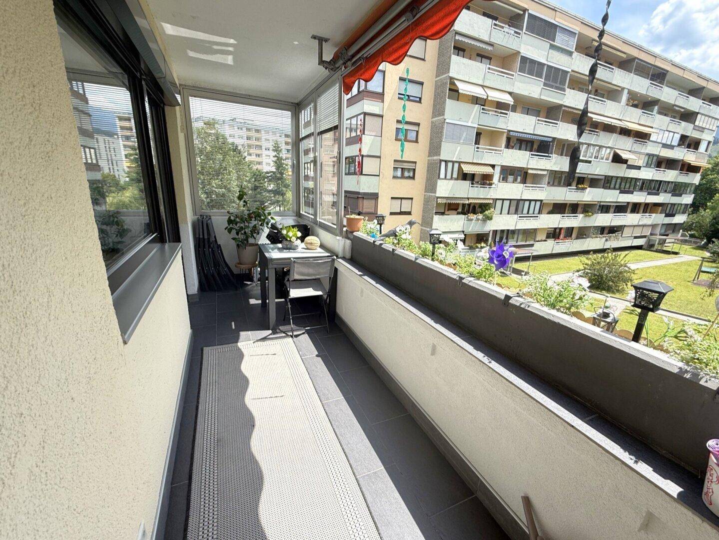 Langer Balkon mit Verglasung, der zusätzlichen Wohnraum im Freien bietet.