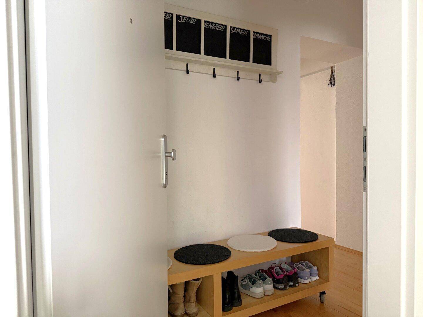 Eingangsbereich mit Schuhbank, Garderobe und Wandtafel, praktisch und einladend.