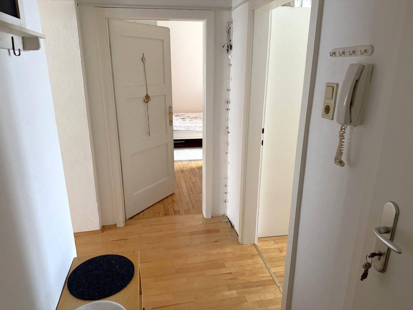Heller Flur mit Holzboden und Türen zu angrenzenden Räumen, funktional gestaltet.