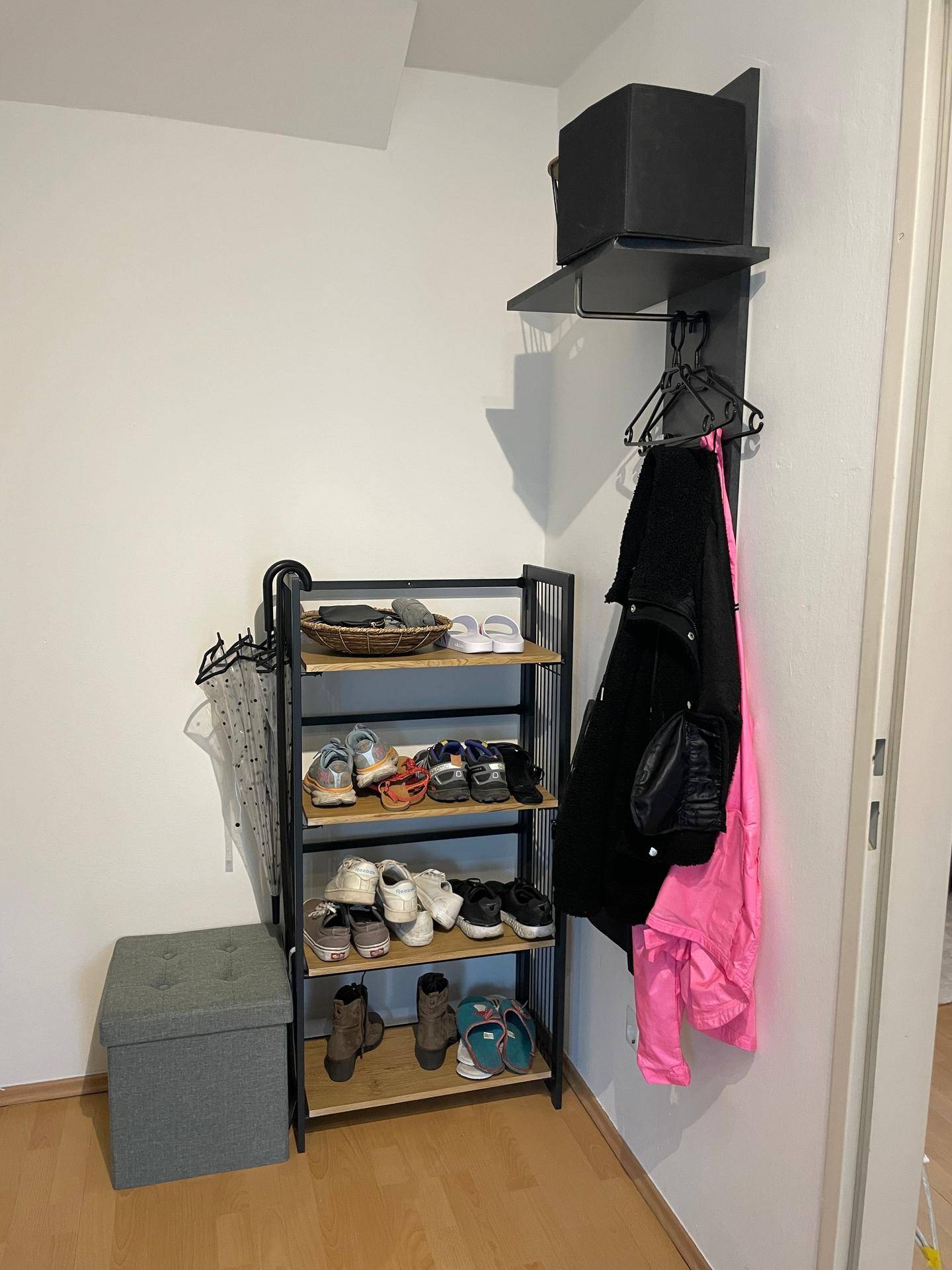 Eingangsbereich mit praktischem Schuhregal, Garderobe und hellem Laminatboden für Ordnung.