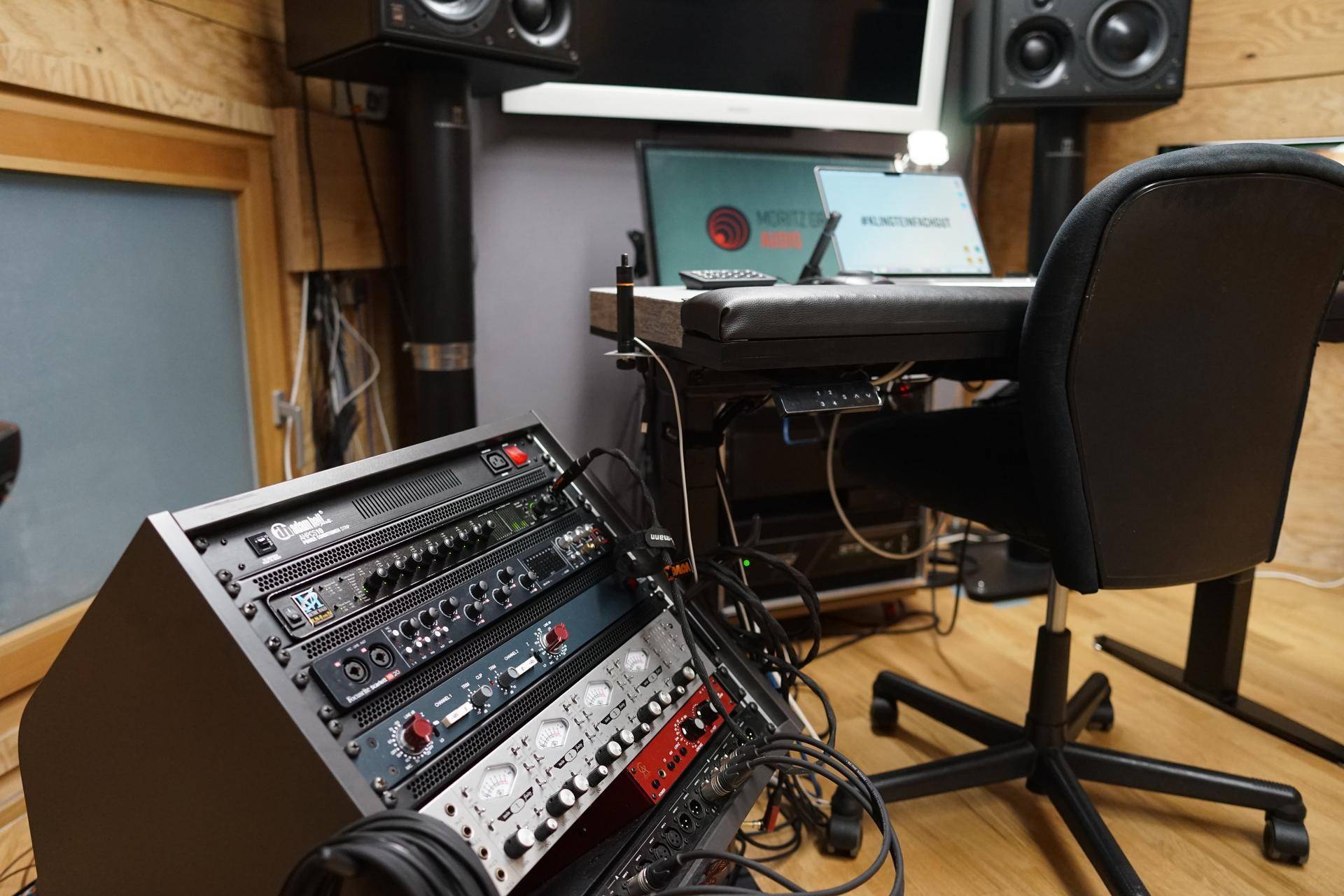 Nahaufnahme eines professionellen Audio-Racks mit verschiedenen Geräten und Bedienelementen im Studio.