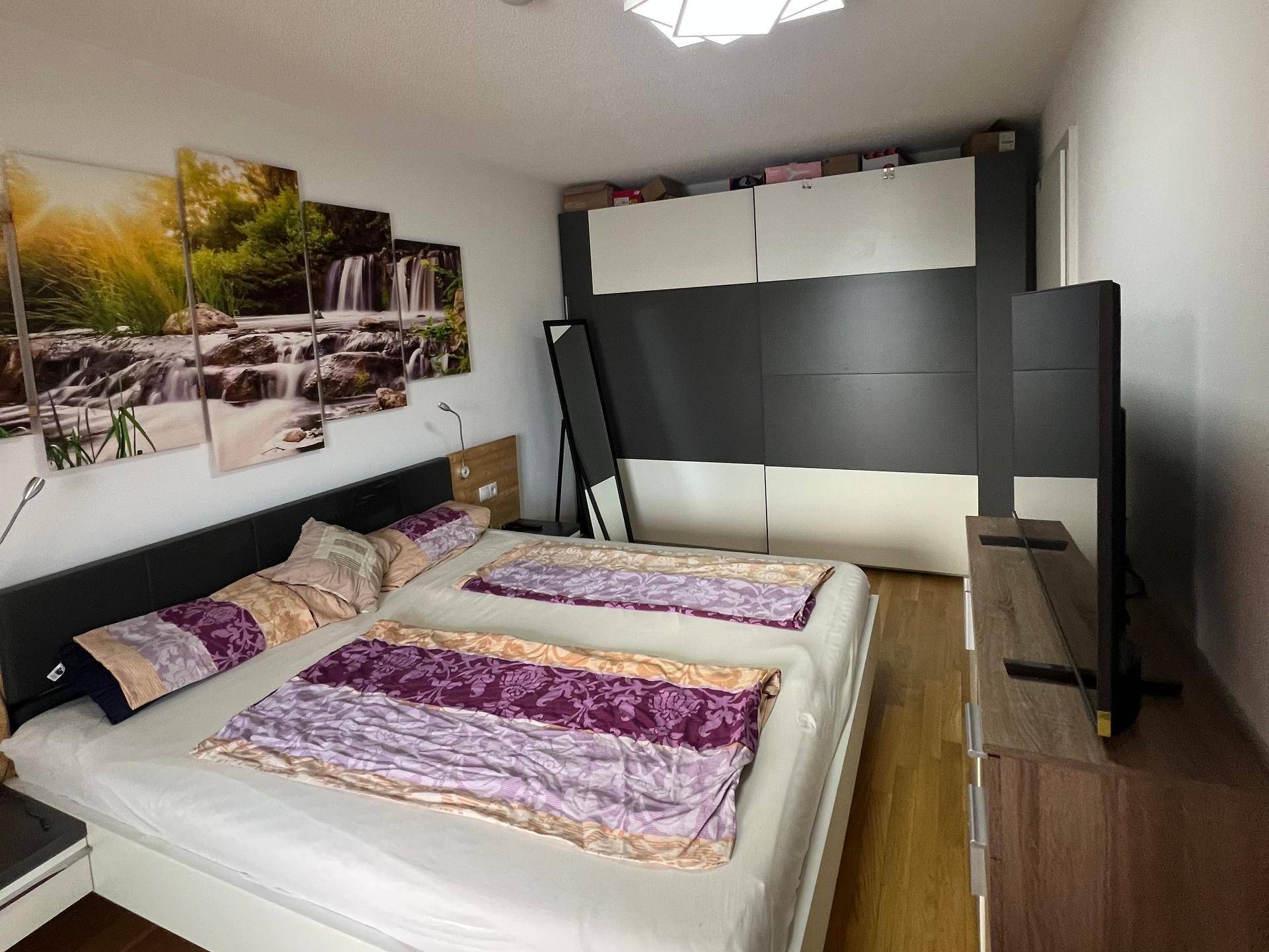 Schlafzimmer mit großem Kleiderschrank, Holzboden und gemütlicher Atmosphäre.