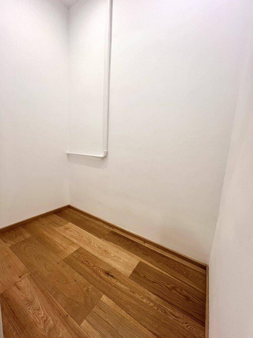 Kleiner Abstellraum mit Holzparkettboden und weißen Wänden, ideal für zusätzlichen Stauraum.