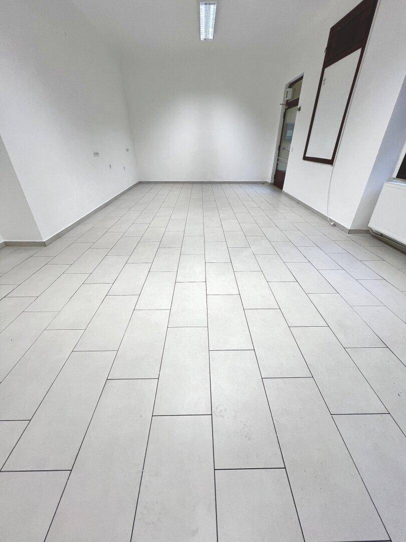 Geräumiger, heller Innenraum mit schrägen Wänden und Fliesenboden, bereit für individuelle Gestaltung.