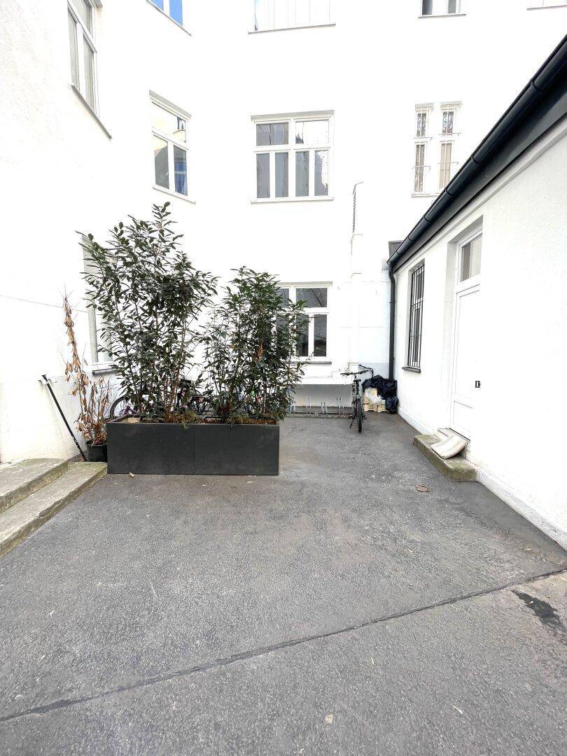 Kleiner Balkon mit Markise und Blick in den Innenhof, ideal für Entspannung im Freien.