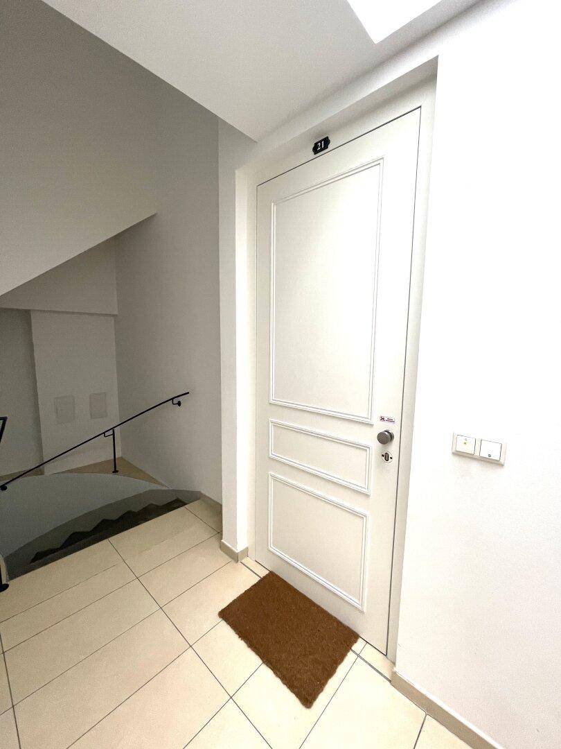 Eingangstür zur Wohnung mit Fußmatte und Zugang zum Treppenhaus, hell und einladend.