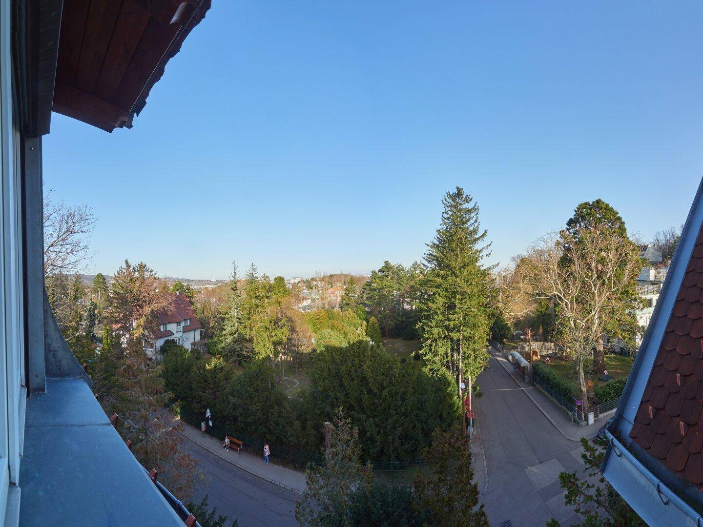 Panoramablick von einem Balkon über eine grüne Landschaft und die Stadt.
