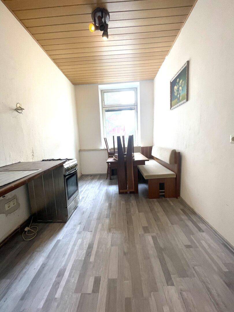 Funktionale Küche mit Essbereich, Holzdecke und einem Fenster, bietet Platz für Mahlzeiten.