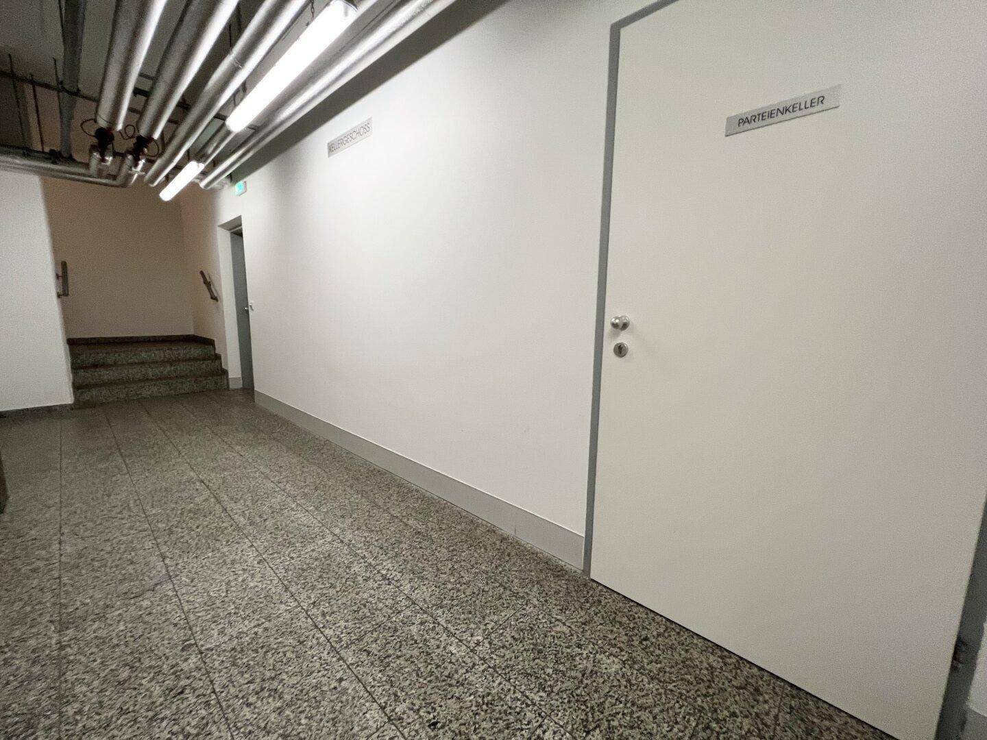 Kellerflur mit Türen zu den einzelnen Parteienkellern und funktionaler Beleuchtung.