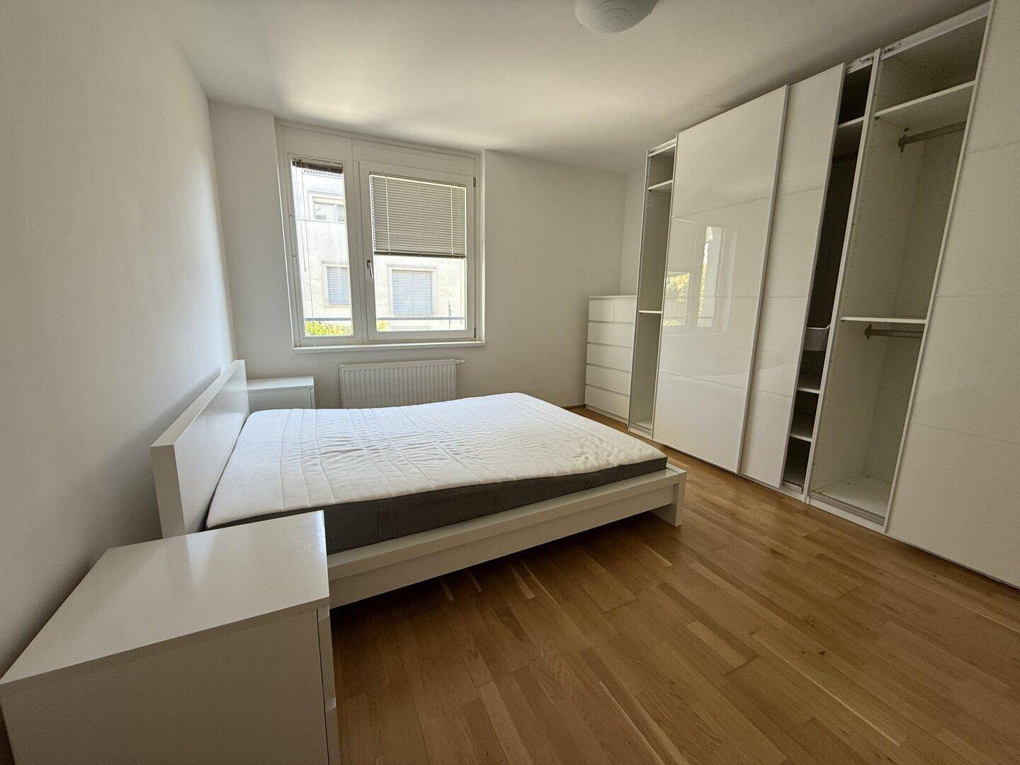Geräumiges Schlafzimmer mit Doppelbett, Nachttischen und großen, modernen Einbauschränken.