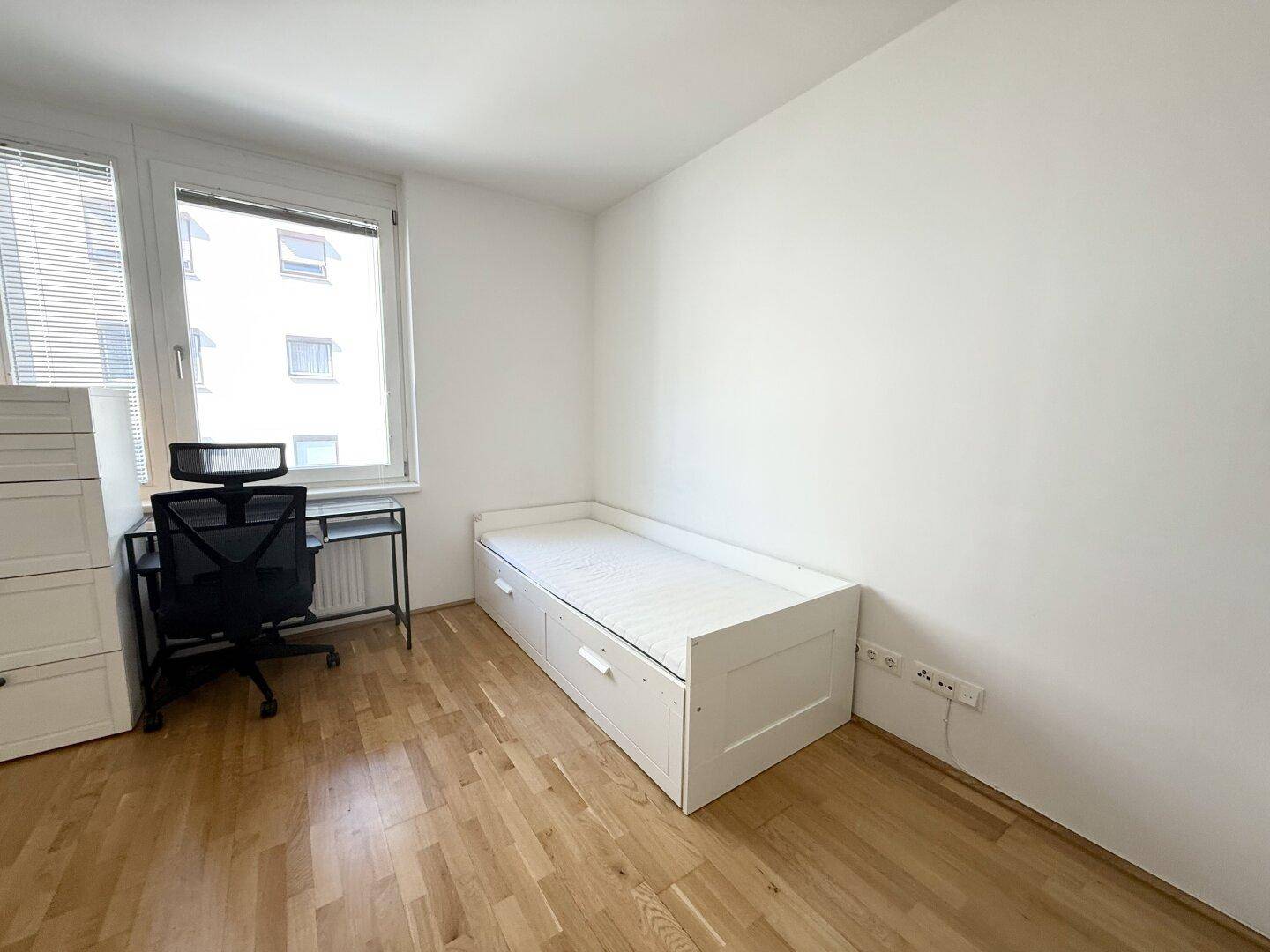 Helles Zimmer mit Tagesbett, Schreibtisch und großem Fenster, ideal als Gäste- oder Arbeitszimmer.