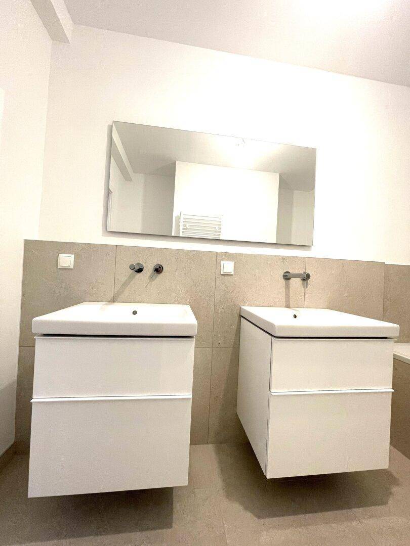 Nahaufnahme der modernen Doppelwaschbecken mit minimalistischem Design im Badezimmer.