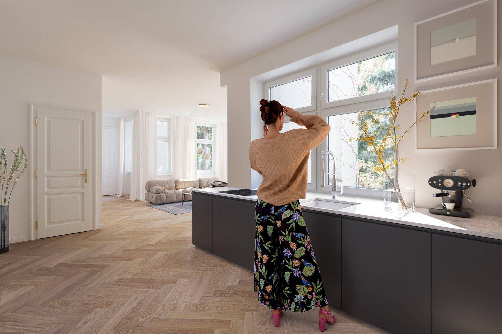 Moderne Küche mit dunklen Unterschränken, heller Arbeitsplatte und Blick ins Grüne durch das Fenster.