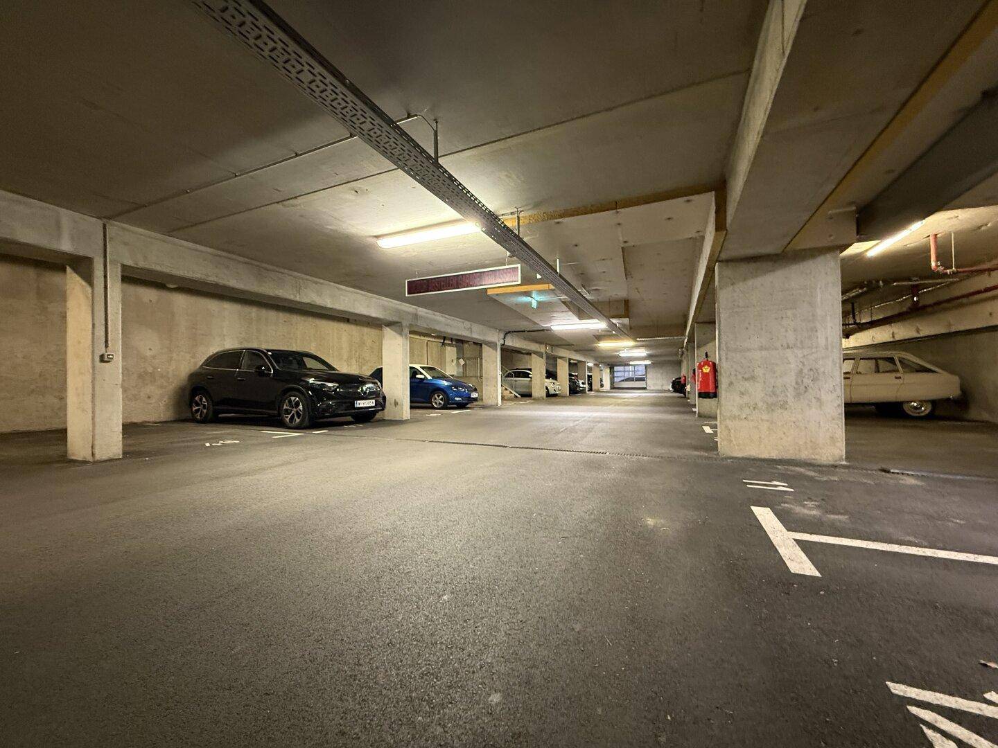 Tiefgarage mit mehreren Stellplätzen und ausreichend Platz für Fahrzeuge.