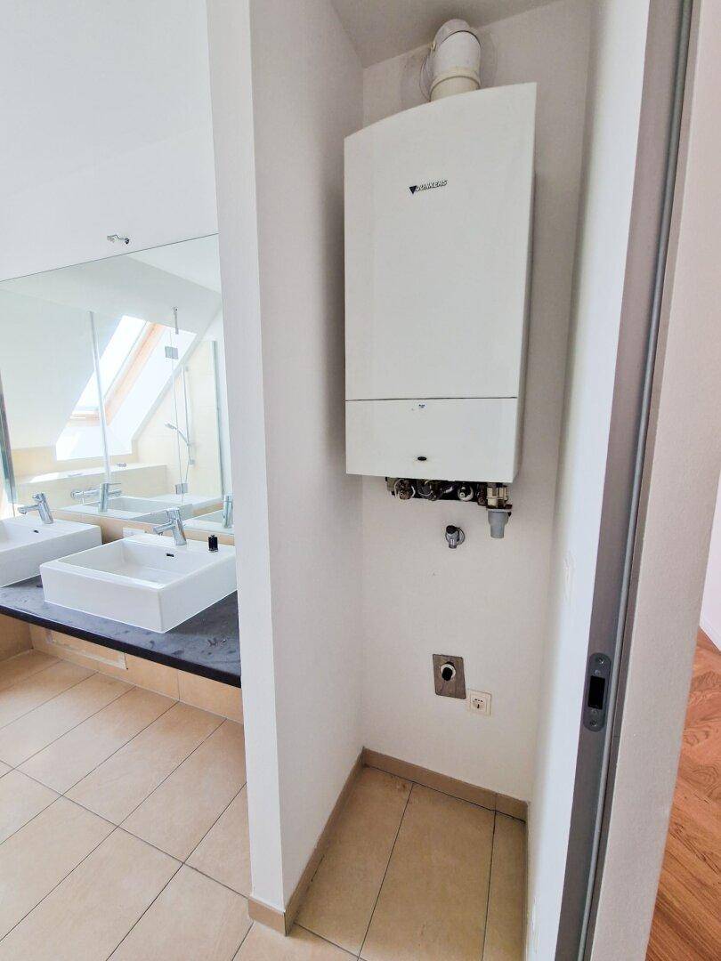 Praktischer Bereich mit Gastherme und Anschluss für eine Waschmaschine, funktional und platzsparend.