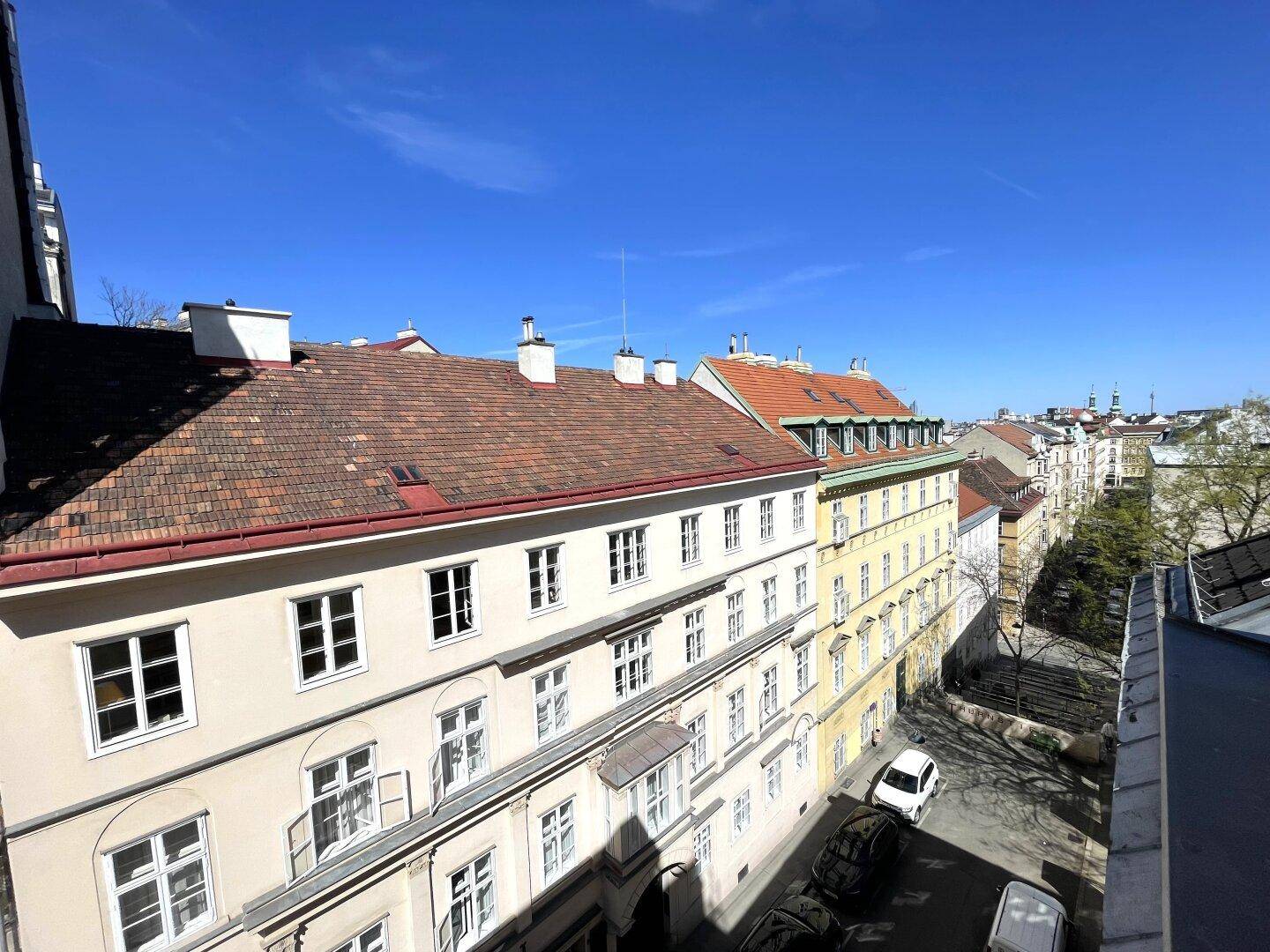 Blick über die Dächer der Stadt mit historischen Gebäuden und blauem Himmel.
