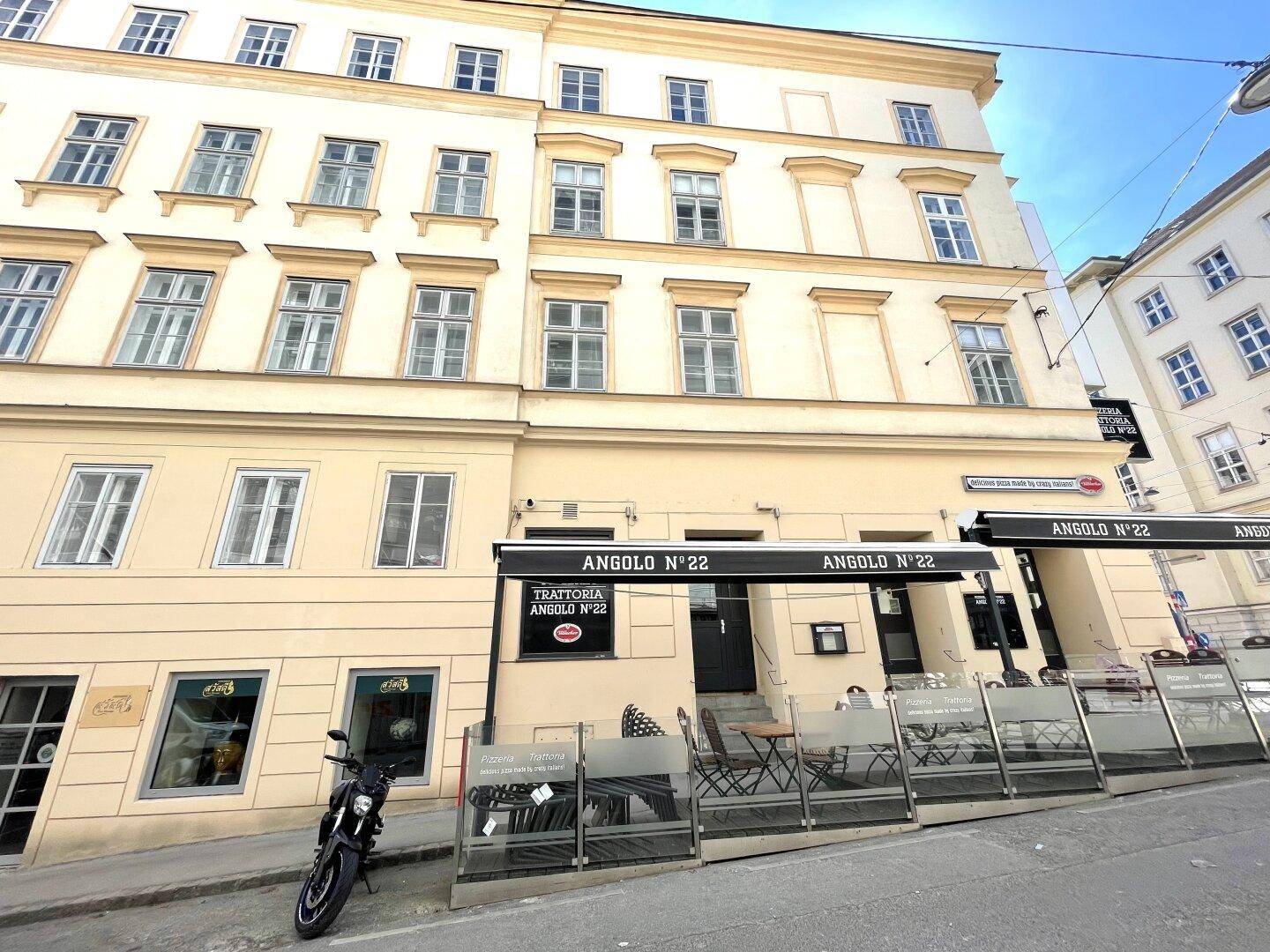 Historisches Gebäude mit Geschäften im Erdgeschoss und traditioneller Architektur.