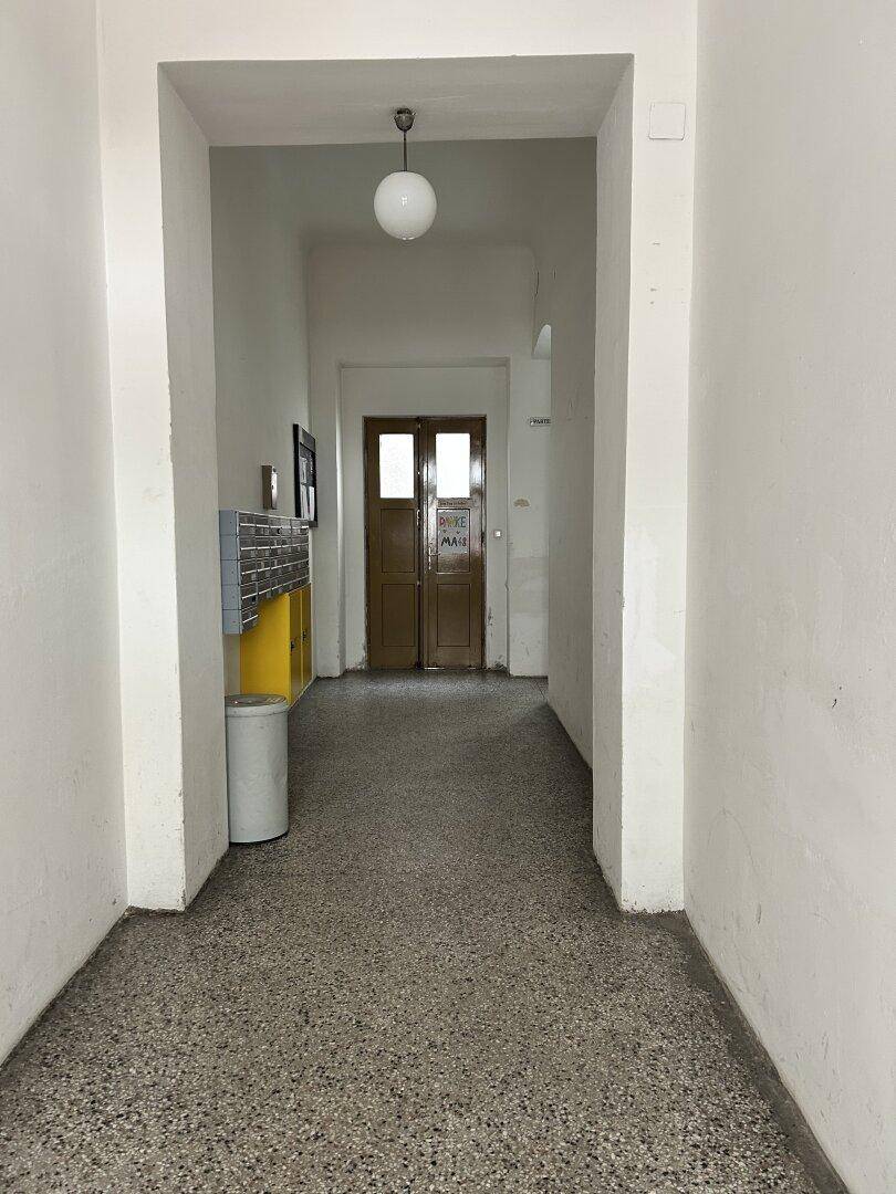 Eingangsbereich eines Mehrfamilienhauses mit Briefkästen und Zugang zu den Wohnungen.