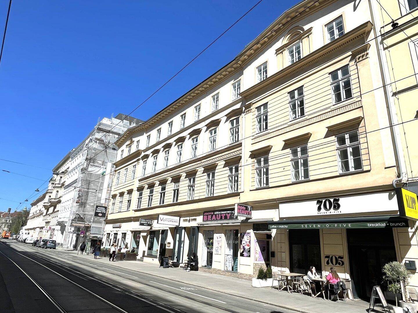 Lange Reihe von historischen Gebäuden entlang einer Straße mit Geschäften im Erdgeschoss.