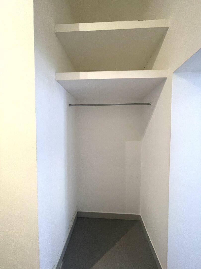Kleiner Abstellraum mit Regalen und Kleiderstange für zusätzlichen Stauraum.