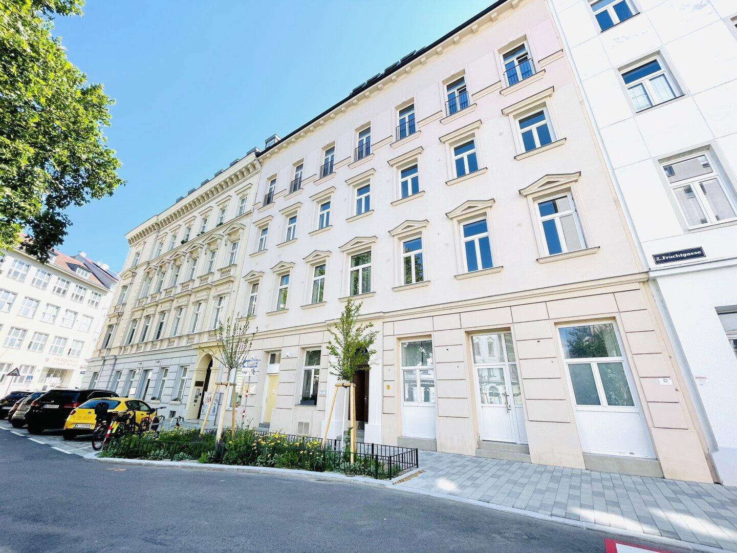 Attraktive Fassade eines Mehrfamilienhauses mit vielen Fenstern und gepflegtem Eingangsbereich.