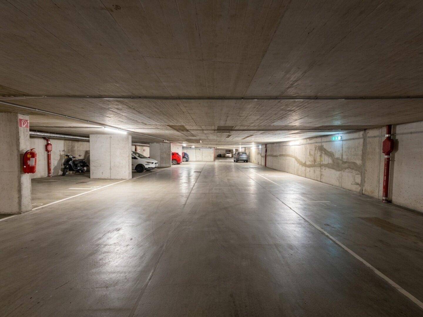Geräumige Tiefgarage mit vielen Stellplätzen und Betonwänden.