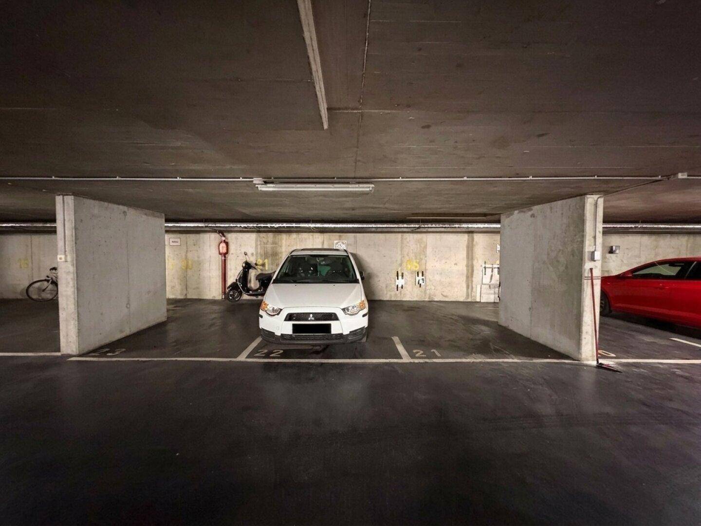 Einzelner Stellplatz in der Tiefgarage mit Betonpfeilern.