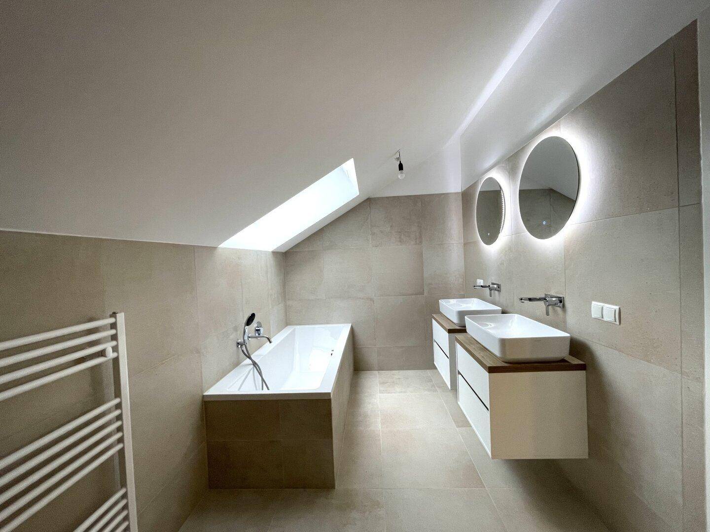 Helles modernes Badezimmer mit Badewanne, Doppelwaschbecken, Dachschräge und Oberlicht.