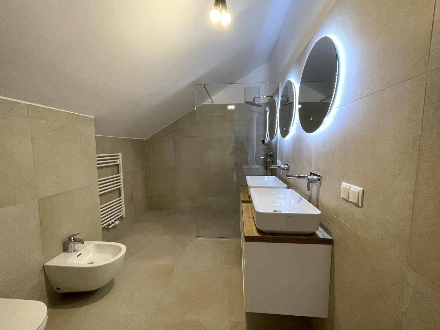Modernes Badezimmer mit begehbarer Dusche, Bidet, Doppelwaschbecken und Dachschräge.