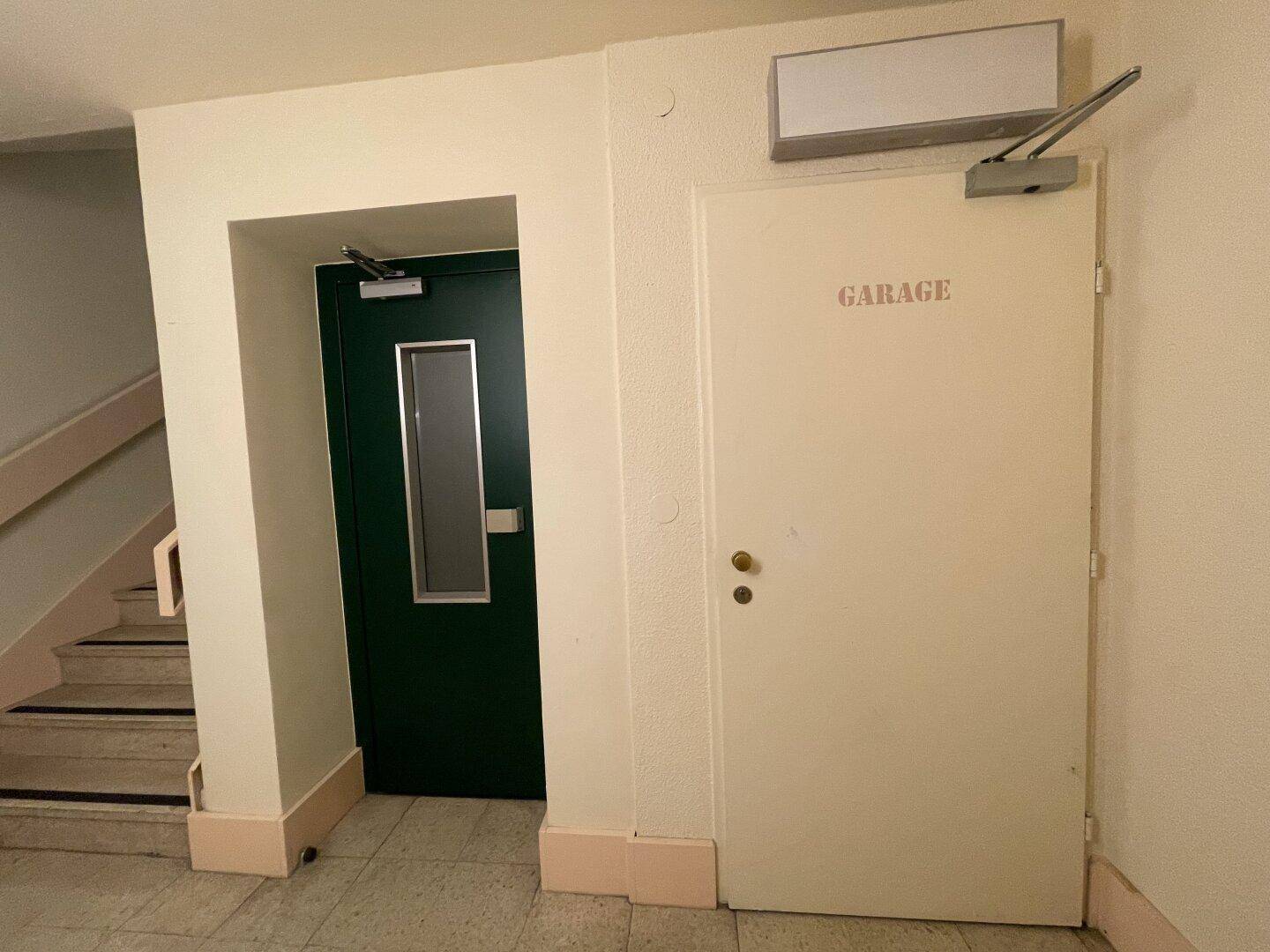 Flur mit Treppenaufgang und Zugang zur Garage sowie einem weiteren Bereich.