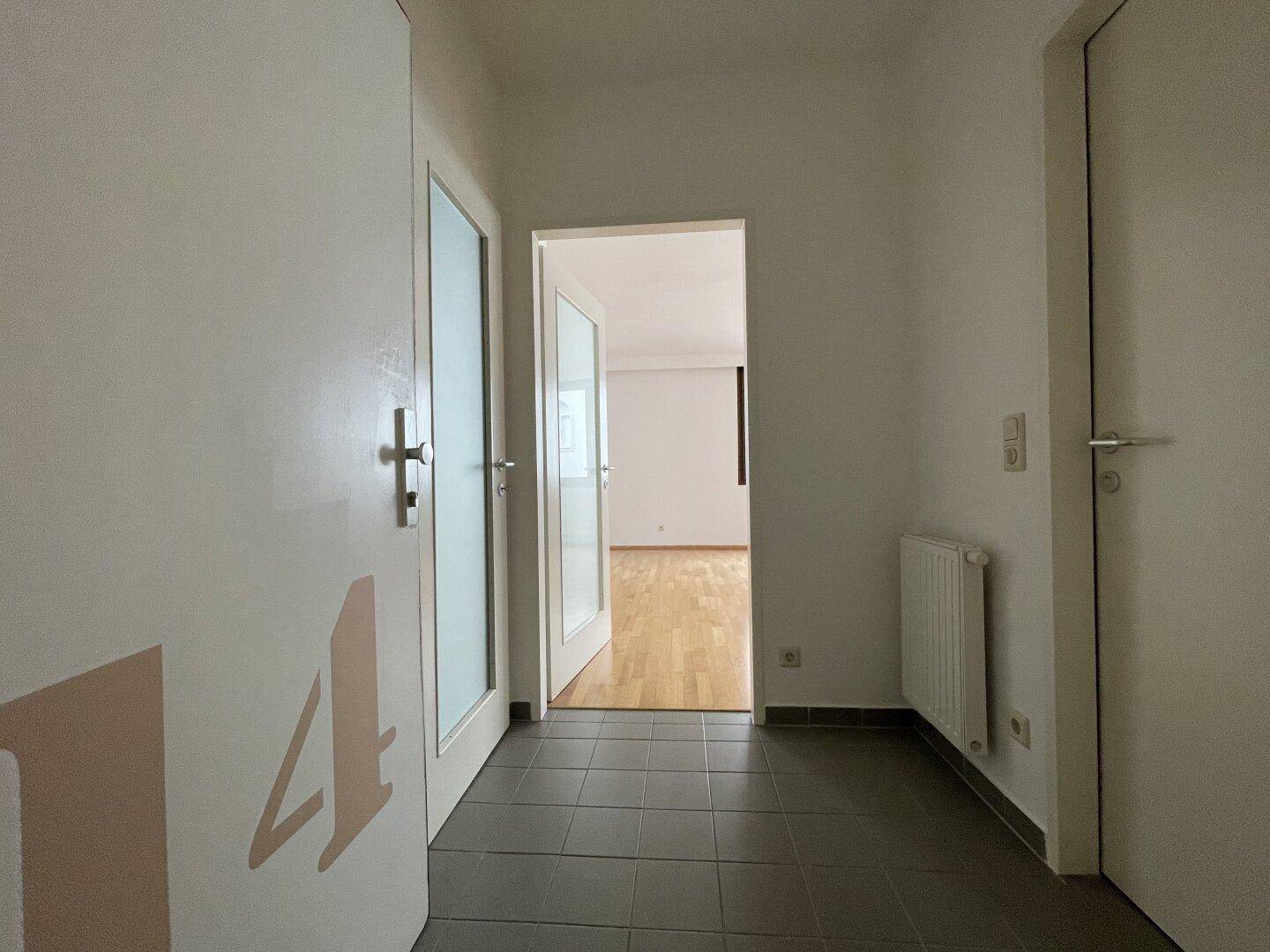 Heller Flur mit Fliesenboden und Zugang zu den verschiedenen Räumen der Wohnung.