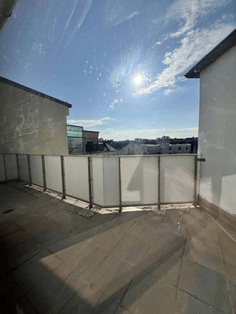 Geräumige Dachterrasse mit moderner Brüstung und viel Sonnenlicht.