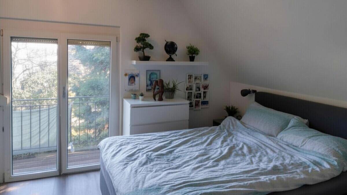 Helles Schlafzimmer mit Zugang zu einem Balkon und modernem Dekor.
