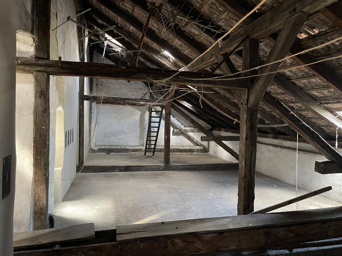 Geräumiger Dachboden mit sichtbaren Holzbalken und Potenzial zum Ausbau.