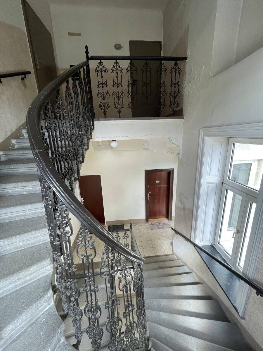 Elegantes Treppenhaus mit schmiedeeisernem Geländer und historischem Charme.