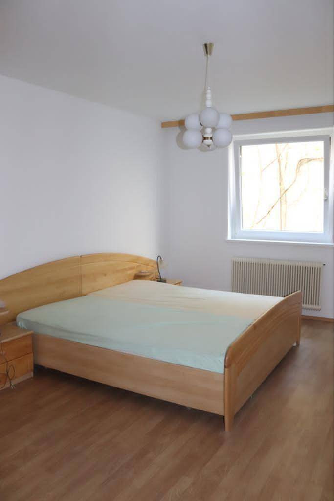 Geräumiges Schlafzimmer mit Doppelbett, Holzboden und einem Fenster für natürliche Belichtung.