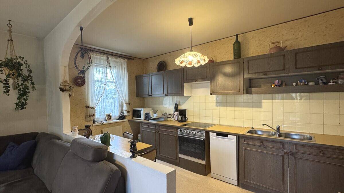 Funktionale Küche im traditionellen Stil mit Einbaugeräten und halbhoher Trennwand zum Wohnbereich.