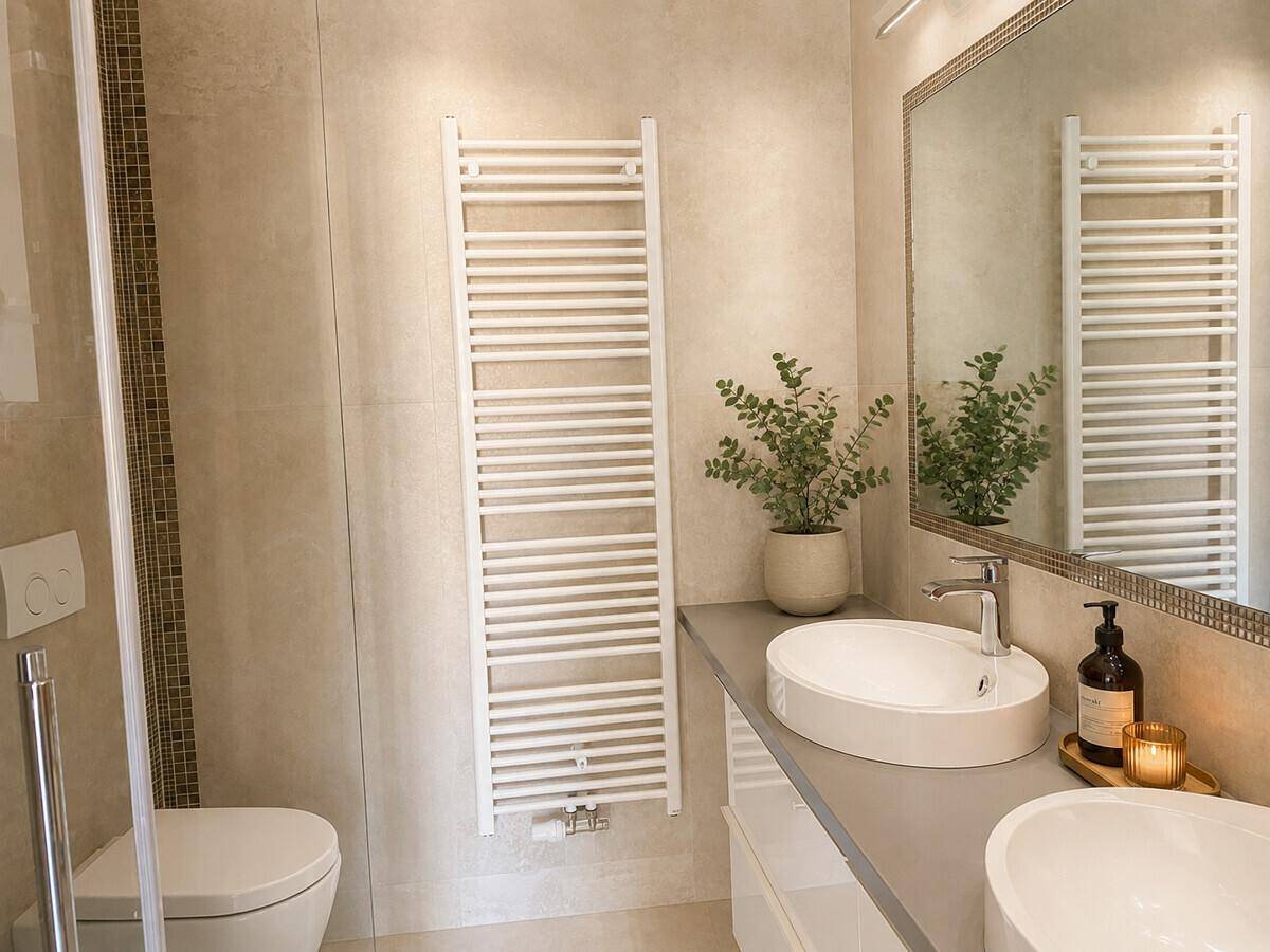 Modernes Badezimmer mit zwei Aufsatzwaschbecken, großem Spiegel und beheiztem Handtuchhalter.